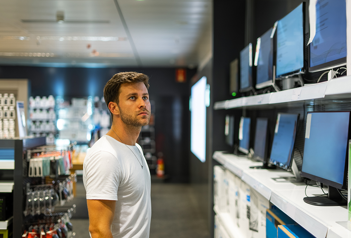 Man looking at a computer in a computer repair store