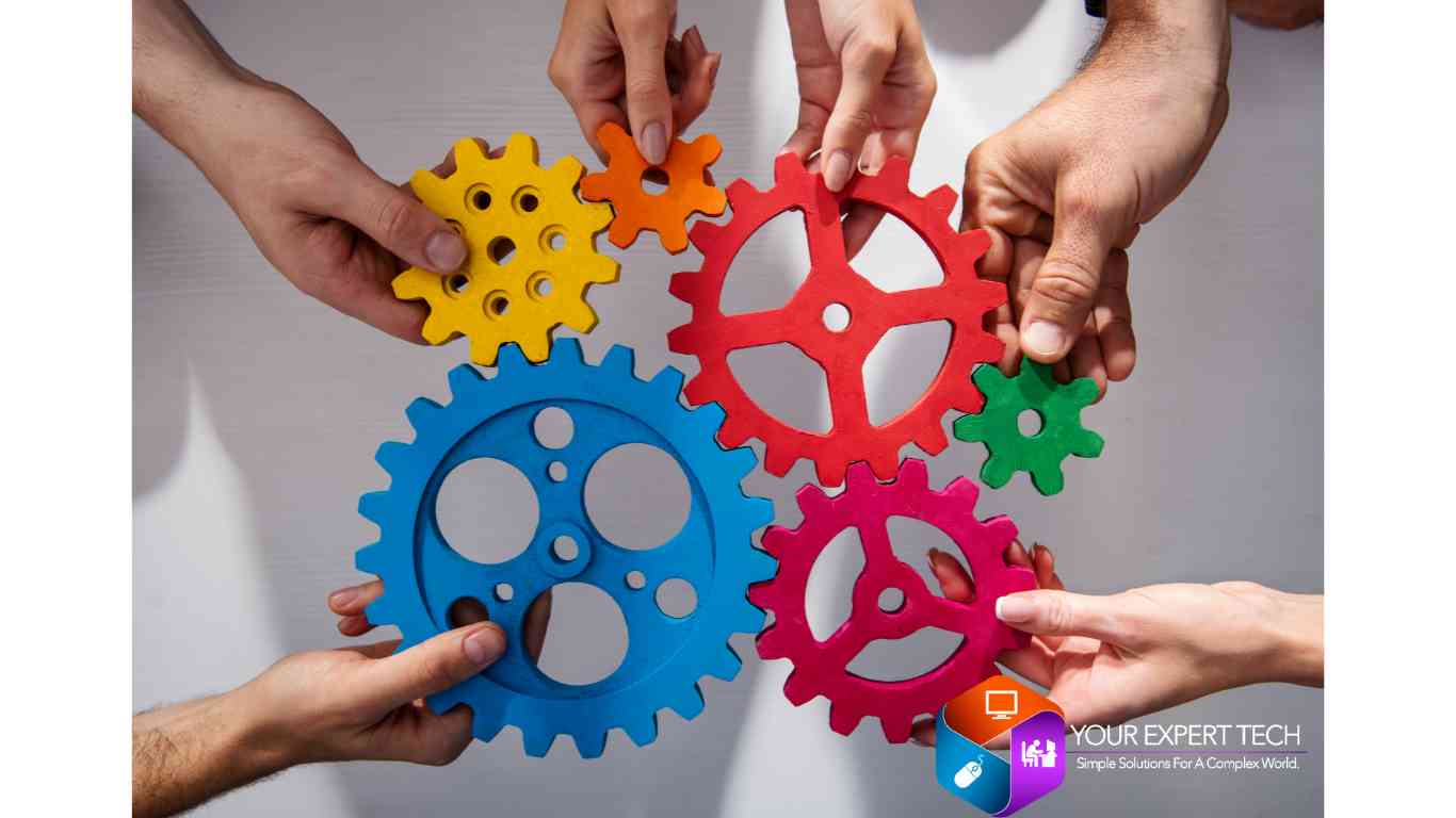 An image of people holding large gears together, symbolizing collaboration and partnership in a teamwork-focused setting.